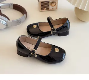 Dettaglio scarpe Mary Jane in vernice nera con rosa dorata e cinturino con fibbia