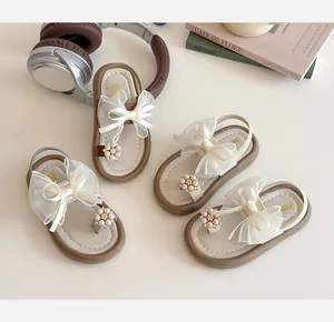 Detailed view of girls' sandals featuring mesh bows, pearl accents, and elastic heel straps