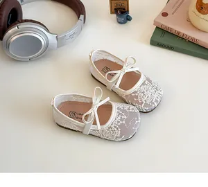 Détail de chaussures de princesse pour fillettes avec dentelle florale et nœud en ruban