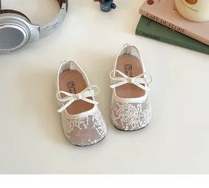 Gros plan de chaussures de princesse en dentelle pour filles avec nœud et paillettes