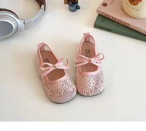 Détail de chaussures Mary Jane roses en dentelle pour fille avec broderie et nœud