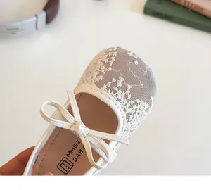 Détail de chaussures bébé en dentelle blanche avec nœud et bordure en cuir souple