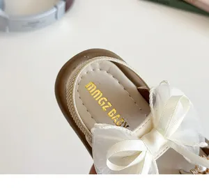 Close-up of girls' princess sandal featuring organza bow and crown pearl pendant detail