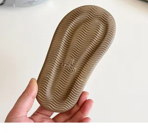Detail of soft brown rubber sole with non-slip wavy texture and size mark for girls sandals