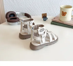 Detalle de sandalias romanas beige para niñas con correas y cremallera trasera