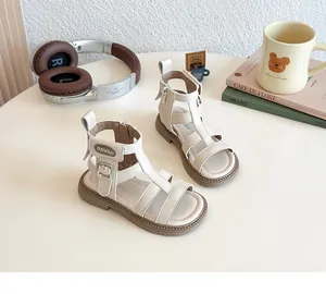 Detalle de sandalias gladiadoras beige para niñas con tiras y suelas de goma gruesas
