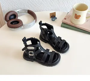 Detalle de sandalias gladiadoras negras para niñas con diseño de tiras y suelas de goma