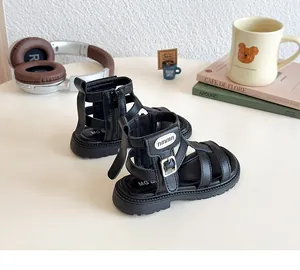 Detalle de sandalias romanas negras para niña con suelas blandas y cremallera trasera