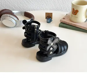 Detail of girls' black gladiator sandals with rhinestone butterfly and rear zipper