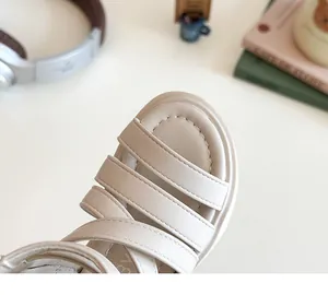 Close-up of beige girls' Roman sandals with multilayer leather straps and soft insoles