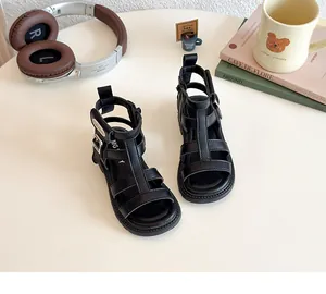 Detalle de sandalias gladiadoras negras para niñas con tiras y cremallera en el talón