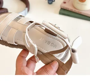 Primer plano del talón suave flexible y el lazo decorativo de las sandalias de niña