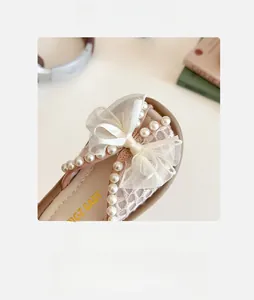 Détail du nœud en dentelle avec perles et maille respirante sur sandales pour filles