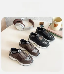 Détail de baskets pour enfants avec boucles métalliques et empiècements serpent