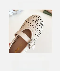 Detail of cream girls Mary Jane shoes with laser-cut hollow pattern and wide round toe