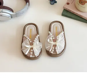 Vue détaillée de mules pour enfants avec dentelle, perles et nœud en résille rose