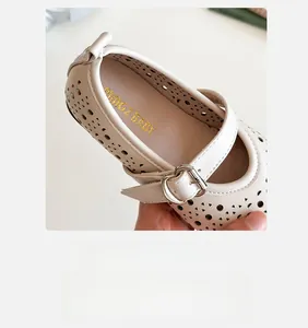 Close-up of beige girls Mary Jane shoe with heart-shaped laser-cut patterns