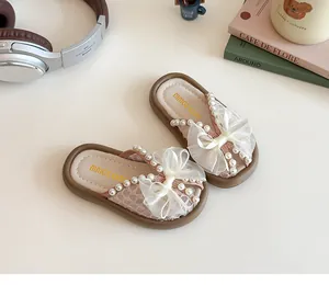 Détail de sandales roses pour enfants avec nœud en résille, perles et texture matelassée