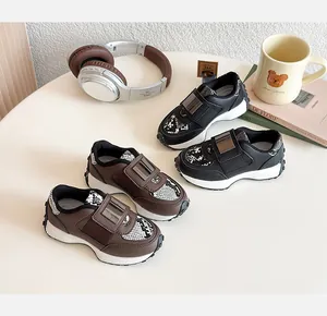 Détail de baskets pour enfants avec motifs serpent et boucle métallique décorative