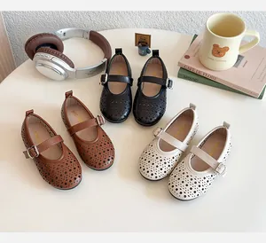 Close-up of girl's Mary Jane shoes with laser-cut petal patterns and metal buckles