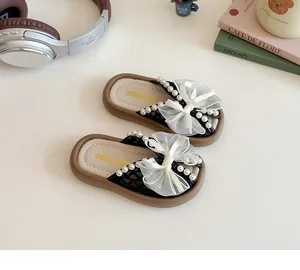Vue détaillée de dessus des mules noires pour filles avec perles et nœud en résille