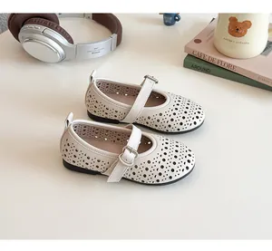 Detail showing beige girls' Mary Jane shoes with laser-cut patterns and heart buckle