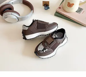 Détail de baskets pour enfants avec tons café et motifs serpent sur la bride velcro