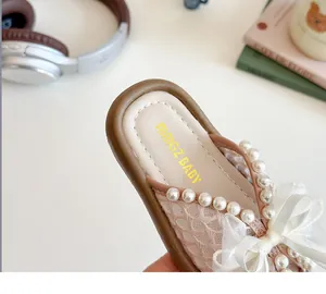 Gros plan de chaussons en maille rose avec nœud en velours et perles pour filles