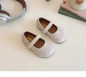 Close-up of sparkling sequin Mary Jane shoes for girls with ivory elastic strap detail