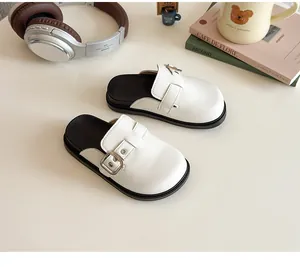 Vista dall'alto di sabot per bambina color crema con fibbie quadrate e suole nere spesse
