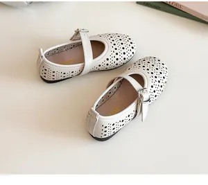 Detail of cream-white girls' Mary Jane shoes featuring elegant hollow-out floral patterns