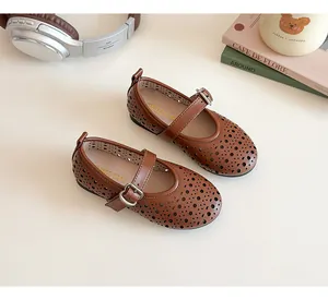Detailed view of brown hollow-out girls Mary Jane shoes with laser-cut geometric patterns