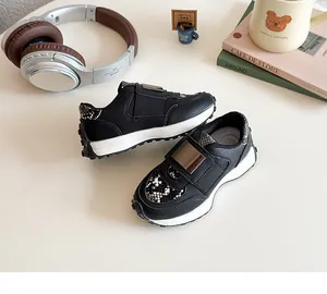 Détail des baskets noires à scratch avec texture peau de serpent et boucle métallique