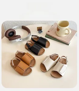 Detailed view of girls' open-toe sandals in black, brown and beige with cork texture footbed