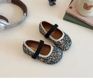 Top view of girls' black sequined Mary Jane shoes with ruffled elastic straps and white trim