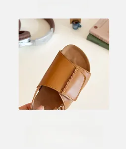 Detail close-up of brown faux leather open-toe sandals featuring a spacious round toe design