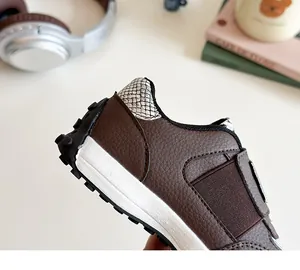 Détail de chaussures de sport enfant en cuir marron avec semelle crantée en caoutchouc
