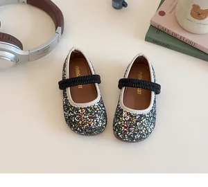 Top view of sequined Mary Jane girls' shoes with elastic straps on a minimalist background