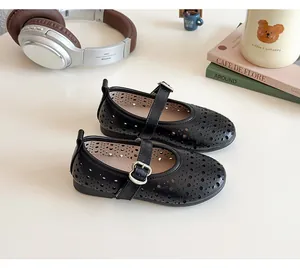 Close-up of girls' black hollow-out Mary Jane shoes with metal buckle and retro floral patterns