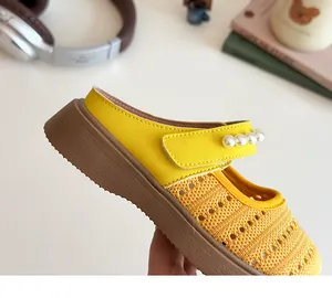 Détail de sandales jaunes pour enfants avec brides à perles et semelles brunes