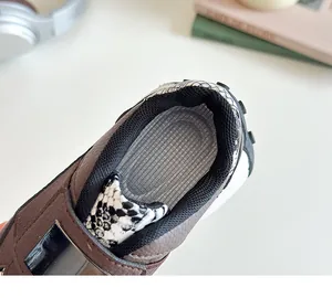 Détail du talon d'une basket pour enfant en cuir grainé marron avec imprimé motif serpent