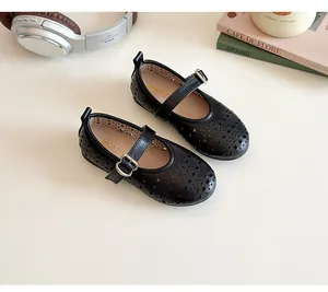 Detailed view of black girls' Mary Jane shoes with laser-cut patterns and buckle strap