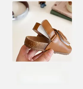 Detail of children's brown leather sandals with adjustable hook and loop strap closure