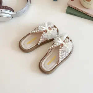 Sandales princesse roses pour filles avec nœud en dentelle et perles sur bureau chic