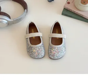 Close-up of girls silver sequin Mary Jane shoes with elastic strap in a cute setting