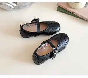 Close-up of girls' black hollowed-out Mary Jane shoes with heart-shaped buckle details