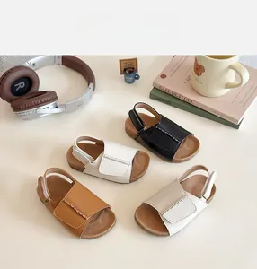 Close-up of girls' faux leather open-toe sandals in black, white, brown and cream colors
