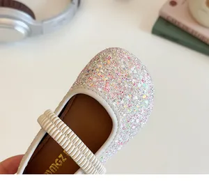 Macro detail of sparkly sequin toe and cream leather strap on girls' Mary Jane shoes
