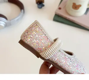Close-up of glittery sequins and elastic strap on toddler girls Mary Jane shoes