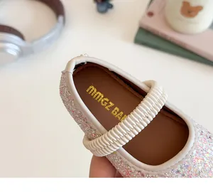 Close-up of pink sequined girls Mary Jane shoe with cream elastic strap and brand insole